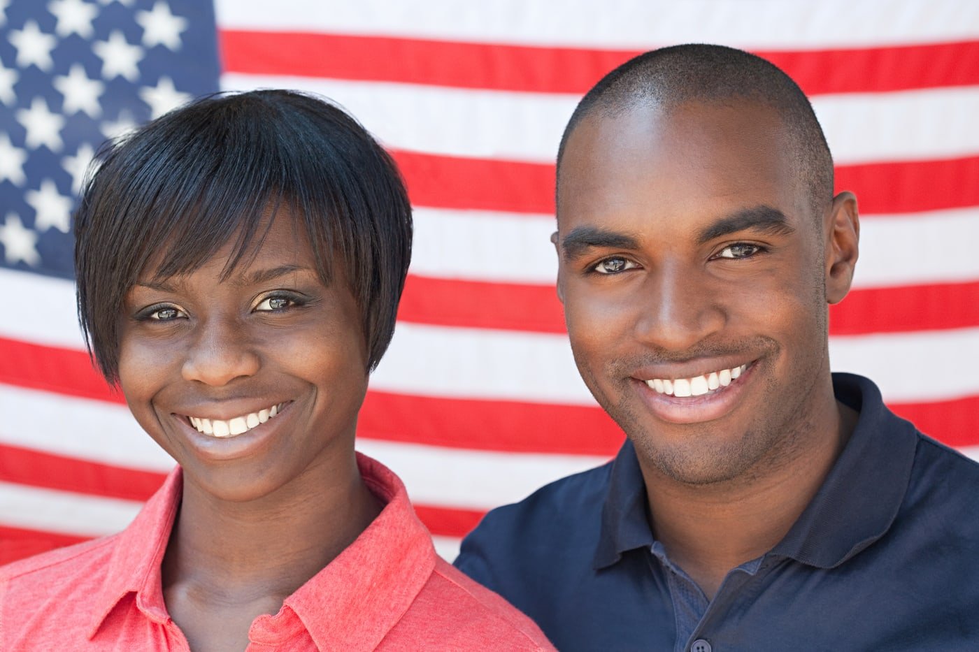 Smiling couple standing in front of an American flag